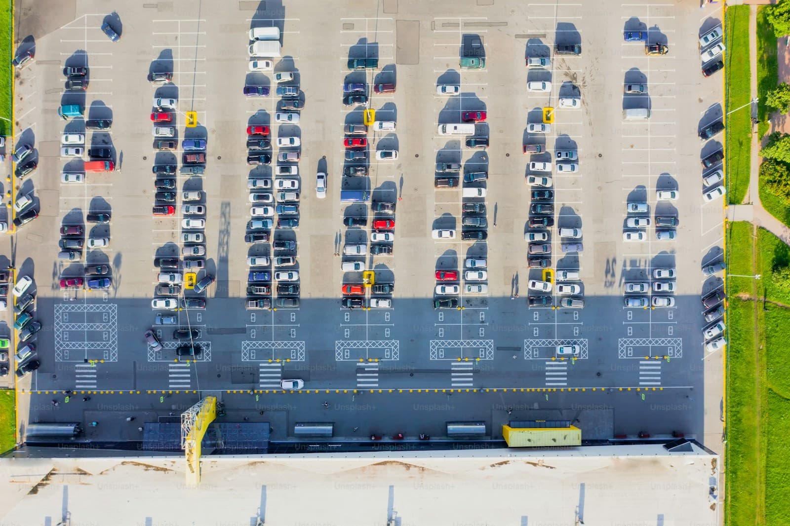 Aerial view of crowded parking lot with cars arranged in rows, showing organized parking spaces from above