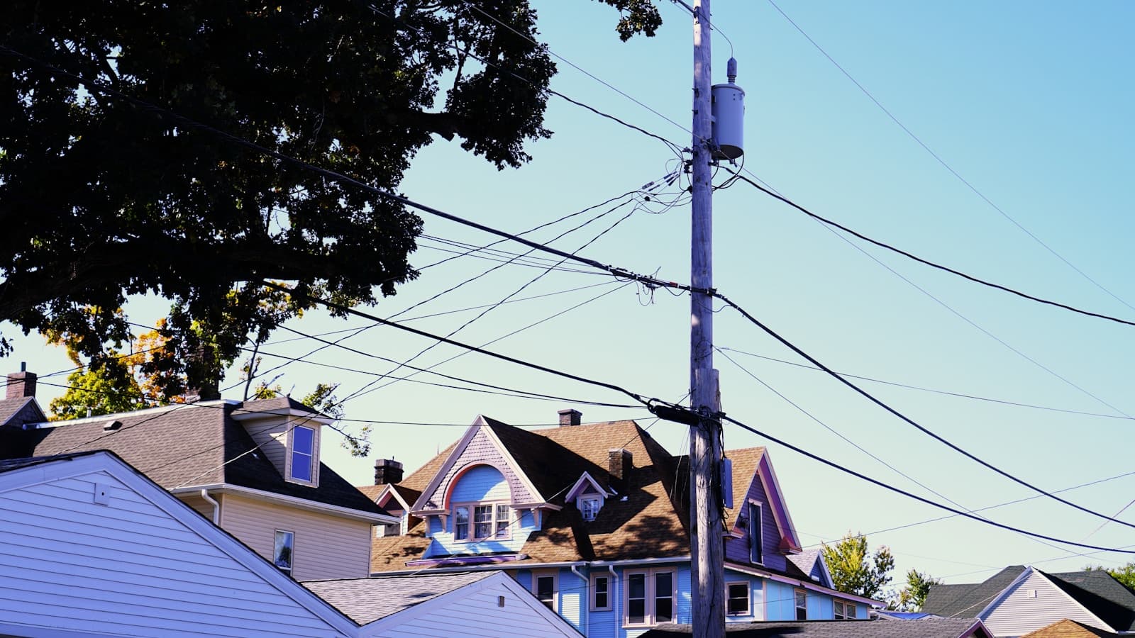 Suburban houses with power lines overhead on a clear day